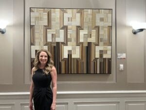 Artist smiling in front of her work
